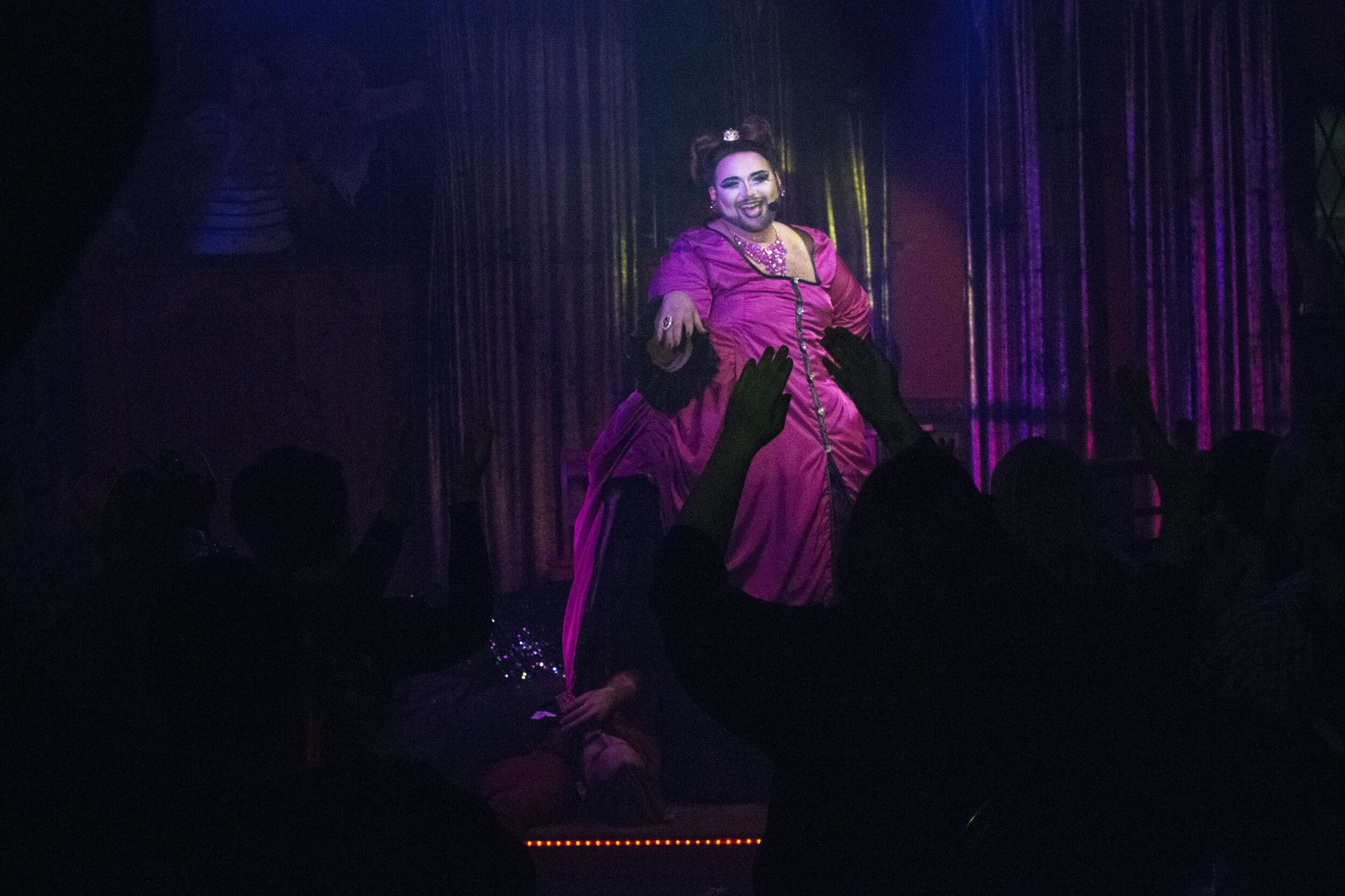 The drag performer Eric Jaffe performing on stage in front of a crowd.