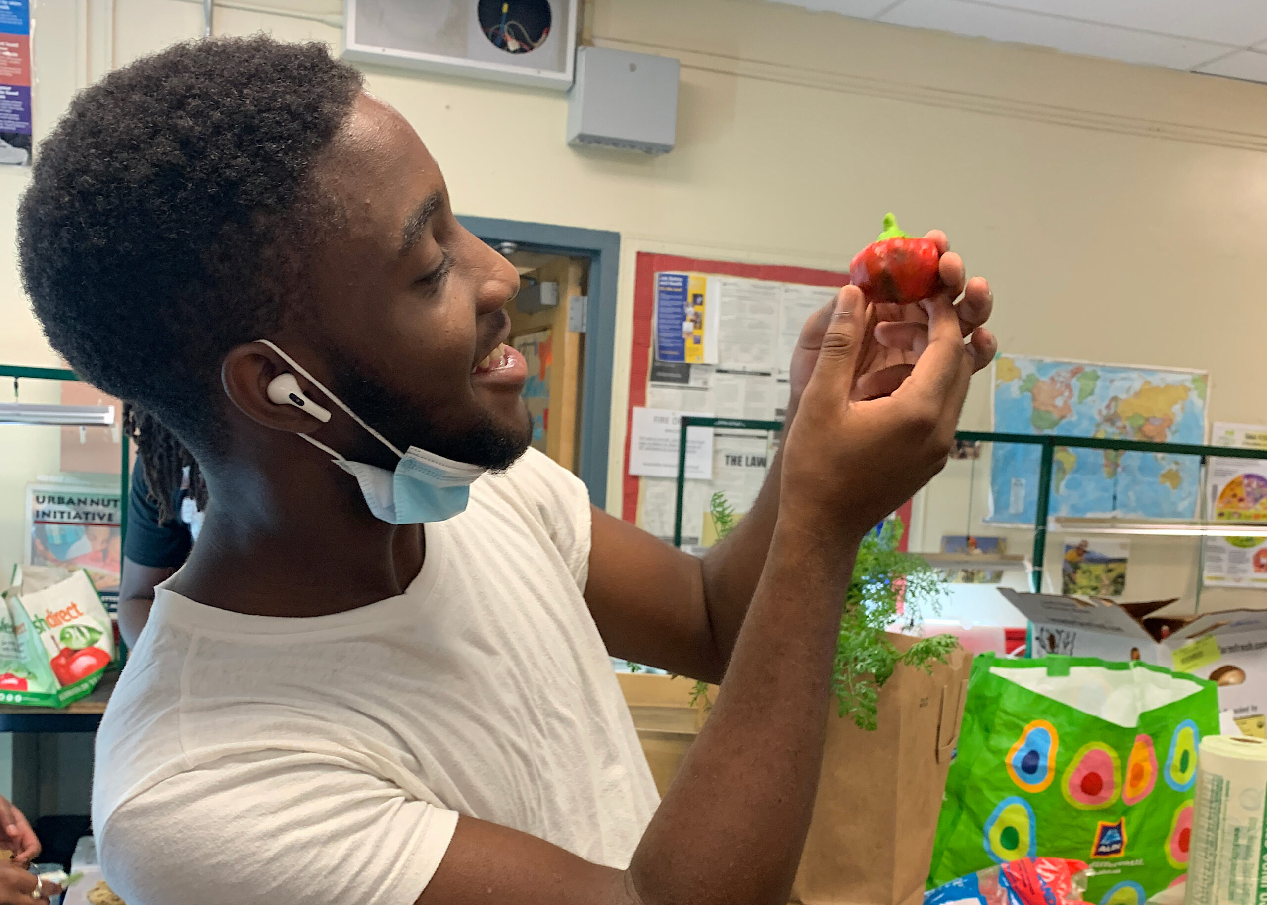 Student from Netter Center AUNI program at Sayre High School looking at a small pepper they planted.