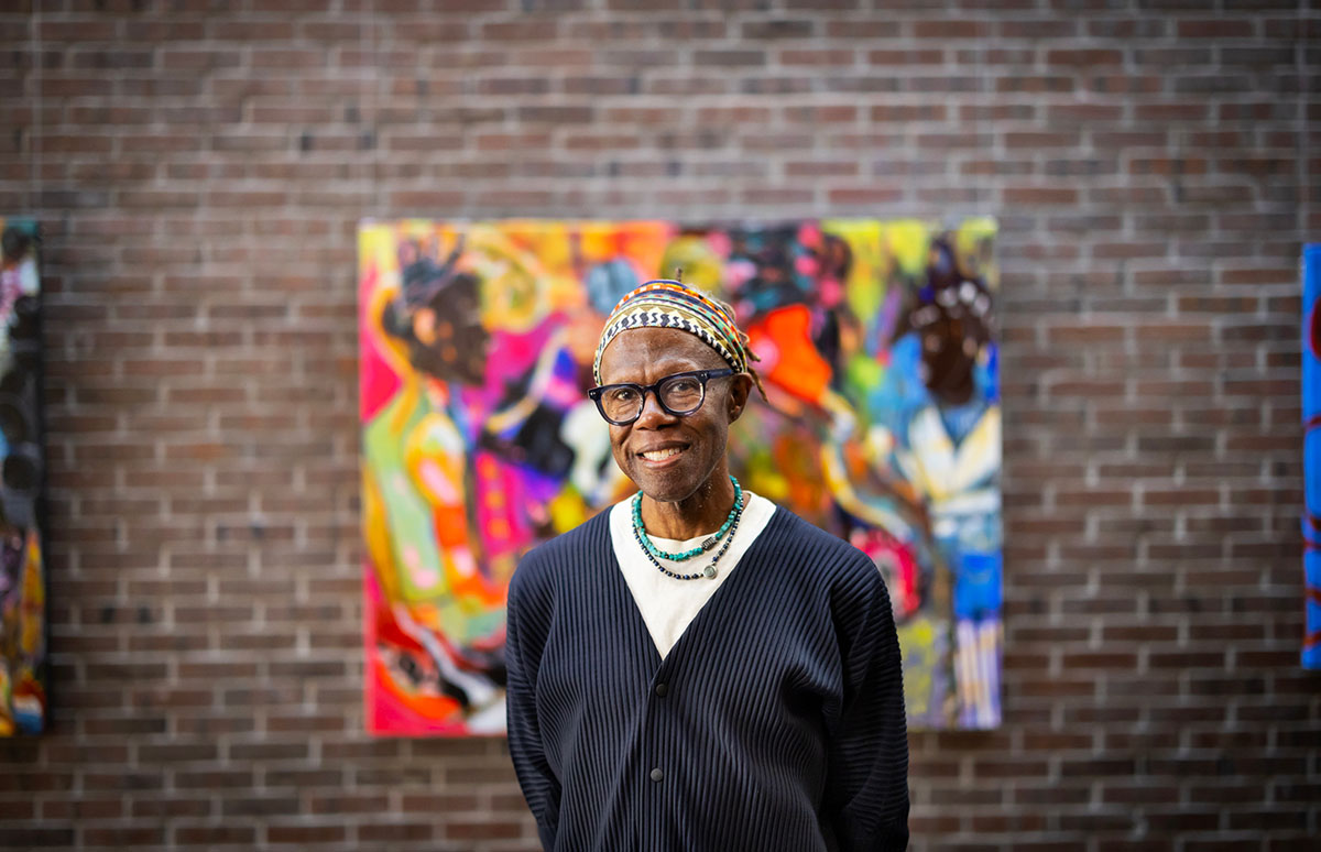 Artist Mikel Elam stands in front of one of his paintings in the Bliss Consciousness exhibition.
